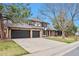 Well-maintained two-story home with a three-car garage and mature trees in a landscaped yard at 4853 S Crystal St, Aurora, CO 80015