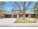 Charming exterior view of a brick home with a large front yard and three-car garage at 4853 S Crystal St, Aurora, CO 80015