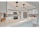 Well-lit kitchen with white cabinets, stainless steel appliances, patterned backsplash, and large countertop space at 4853 S Crystal St, Aurora, CO 80015