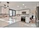 Modern kitchen featuring white cabinets, stainless steel appliances, patterned backsplash, and stylish pendant lighting at 4853 S Crystal St, Aurora, CO 80015