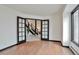 Inviting living room with wood floors, view through glass paneled doors to a staircase, and natural light at 4853 S Crystal St, Aurora, CO 80015