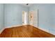 Bedroom featuring hardwood floors, light blue walls, and open doorways at 2421 W 38Th Ave, Denver, CO 80211