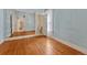 Bedroom with hardwood floors, light blue walls, and large mirror and an adjoining toilet room at 2421 W 38Th Ave, Denver, CO 80211