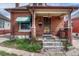 Inviting brick home entrance showcasing a charming porch, detailed door, and well-kept garden at 2421 W 38Th Ave, Denver, CO 80211
