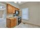 This traditional kitchen has wood cabinets, tile flooring, black appliances, and a view to the living room at 2421 W 38Th Ave, Denver, CO 80211