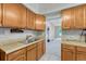 Traditional kitchen with wooden cabinets, double basin sink, and open access to the living room at 2421 W 38Th Ave, Denver, CO 80211