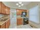 Bright kitchen featuring wooden cabinetry, tile floors, a black range, and a window with natural light at 2421 W 38Th Ave, Denver, CO 80211
