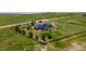 Aerial view showcasing a house surrounded by green fields, a small pond and a scenic landscape at 29333 Rawhide Ct, Elizabeth, CO 80107