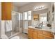 Bright bathroom with a glass enclosed shower, tile floor and a wooden vanity at 29333 Rawhide Ct, Elizabeth, CO 80107