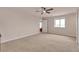 Spacious bedroom featuring neutral carpet, ceiling fan, a large window, and a bright white door at 29333 Rawhide Ct, Elizabeth, CO 80107