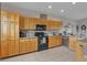 Well-lit kitchen with light wood cabinets, granite countertops, and modern black appliances at 29333 Rawhide Ct, Elizabeth, CO 80107
