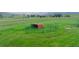 Wide shot of pasture with barn and fence, showcasing the property's spaciousness and rural charm in light green landscape at 29333 Rawhide Ct, Elizabeth, CO 80107