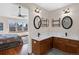 Modern bathroom features double sinks, two mirrors, wooden cabinets, and bedroom view at 3151 E 134Th Cir, Thornton, CO 80241
