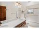 Bright bathroom features dual sinks, modern mirror, and shower-tub combo with glass door at 3151 E 134Th Cir, Thornton, CO 80241