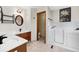 Bathroom with double sinks, wooden cabinets, and walk-in tub with marble wall surround at 3151 E 134Th Cir, Thornton, CO 80241