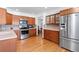 Traditional kitchen with light wood cabinetry, tile backsplash, stainless appliances, and ample storage at 3151 E 134Th Cir, Thornton, CO 80241