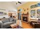 Open concept living room with hardwood floors, brick fireplace, and adjacent eat-in kitchen at 3151 E 134Th Cir, Thornton, CO 80241