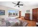 Main bedroom features a ceiling fan, large windows, wood floors, and natural light at 3151 E 134Th Cir, Thornton, CO 80241