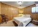 Quaint bedroom with wood paneled walls and a comfortable bed, perfect for relaxation at 10042 Buena Vista Dr, Conifer, CO 80433