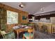 Dining area featuring wood paneling, a round table with seating, and access to the kitchen at 10042 Buena Vista Dr, Conifer, CO 80433