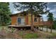 Cozy cabin with a wooden deck and a peaceful wooded setting, ideal for mountain living at 10042 Buena Vista Dr, Conifer, CO 80433