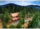 Charming mountain home surrounded by lush trees with a large wrap around deck and stunning mountain views at 10042 Buena Vista Dr, Conifer, CO 80433