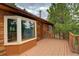 Wood-sided home featuring a deck and windows with scenic views at 10042 Buena Vista Dr, Conifer, CO 80433