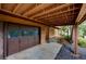 View of the garage and entrance of a charming home nestled beneath an overhanging deck at 10042 Buena Vista Dr, Conifer, CO 80433