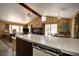 Open kitchen with vintage appliances, wood paneled walls, and eat-in dining space at 10042 Buena Vista Dr, Conifer, CO 80433