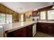Open kitchen with wood paneled walls, vintage appliances, and view of outdoors at 10042 Buena Vista Dr, Conifer, CO 80433