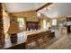 Cozy living room with wood-paneled walls, a fireplace, large windows, and comfortable seating area at 10042 Buena Vista Dr, Conifer, CO 80433