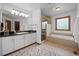 Bathroom featuring dual sinks, a soaking tub, glass shower, and neutral tile floors at 4161 W Lake Cir, Littleton, CO 80123