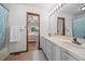 Bright bathroom with double sinks and an adjoining bedroom view through an open door at 4161 W Lake Cir, Littleton, CO 80123