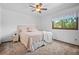 Cozy bedroom featuring neutral tones, a ceiling fan, and large window for natural light at 4161 W Lake Cir, Littleton, CO 80123