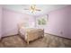Bright bedroom with pink walls, ceiling fan, plush carpeting, and a sunny window at 4161 W Lake Cir, Littleton, CO 80123