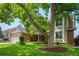 Beautiful home exterior framed by a mature tree and lush landscaping at 4161 W Lake Cir, Littleton, CO 80123