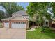 Inviting front exterior showcasing a well-maintained lawn and a charming brick home with a three-car garage at 4161 W Lake Cir, Littleton, CO 80123
