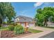 Charming front exterior with well-manicured landscaping, brick accents, and a three-car garage at 4161 W Lake Cir, Littleton, CO 80123