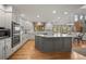 Bright, spacious kitchen featuring white cabinetry, stainless steel appliances, and a large center island at 4161 W Lake Cir, Littleton, CO 80123