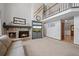 Open living room with a brick fireplace, gray built-in TV console, and second-story balcony at 4161 W Lake Cir, Littleton, CO 80123