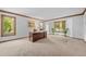 Bright office space with large windows, carpet flooring, and a traditional wood desk at 4161 W Lake Cir, Littleton, CO 80123