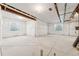 Spacious unfinished basement with concrete floor, wrapped walls, and natural light from egress windows at 8950 Whiteclover St, Littleton, CO 80125