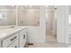 Modern bathroom with a double sink vanity and a glass-enclosed shower with a bench at 8950 Whiteclover St, Littleton, CO 80125