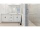 Modern bathroom with double sink vanity, tile floors, and a glass-enclosed shower at 8950 Whiteclover St, Littleton, CO 80125