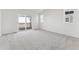 Bright primary bedroom features gray carpet, white walls, and sliding doors to an outdoor living area at 8950 Whiteclover St, Littleton, CO 80125