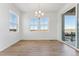 Bright dining area features a modern chandelier, light wood floors, and views through large windows at 8950 Whiteclover St, Littleton, CO 80125