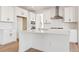 Elegant kitchen island with white cabinetry, stainless steel appliances, and tiled backsplash at 8950 Whiteclover St, Littleton, CO 80125