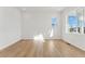 Bright living room with light wood floors, white walls, and a large window for natural light at 8950 Whiteclover St, Littleton, CO 80125