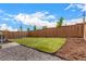 A grassy backyard is bordered by a wooden fence and mulch landscaping at 16432 Snowbourn Dr, Parker, CO 80134