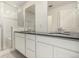 Bathroom featuring double sinks with modern fixtures, white cabinetry, and a sleek, spacious glass enclosed shower at 16432 Snowbourn Dr, Parker, CO 80134